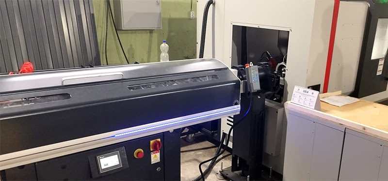 Автоматический податчик прутка, подключенный к токарному станку